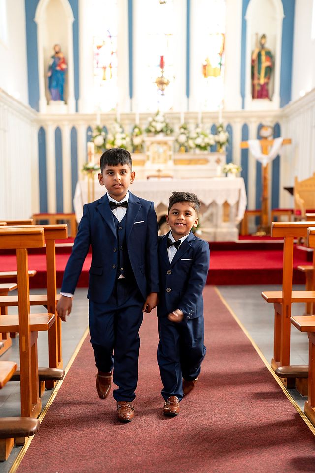 Two boys walking down the church aisle