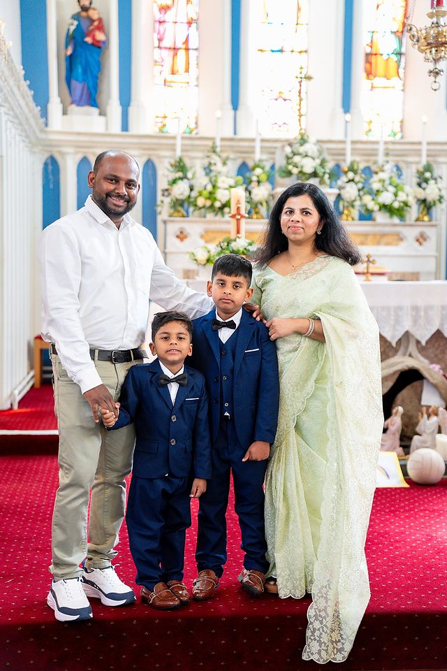 Family with their two boys at the altar after First Holy Communion