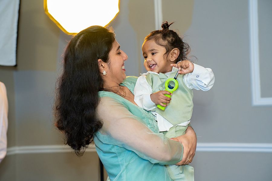 Mother lifting her laughing baby at a first birthday