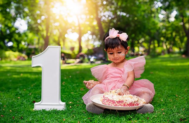 Baby at a first-birthday cake smash in the sun