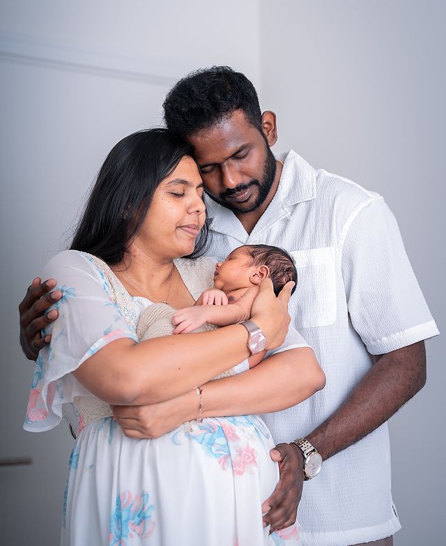Parents cradling their newborn