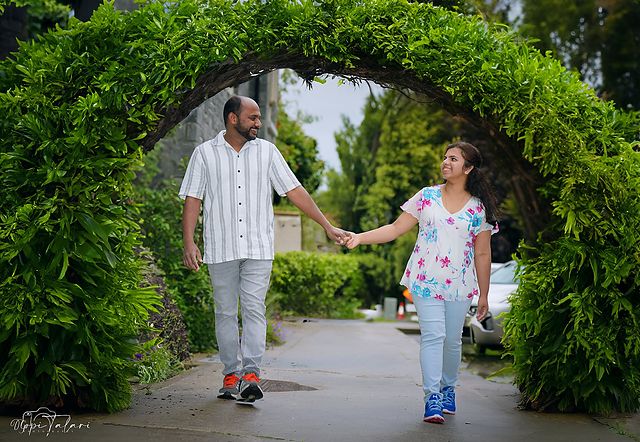 Couple walking through a garden arch