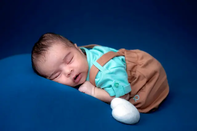 Newborn close-up on navy backdrop