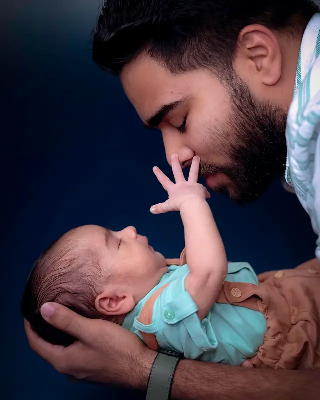 Father with newborn reaching up