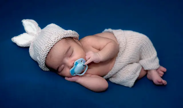 Newborn in bunny bonnet with soother
