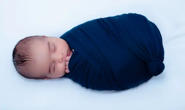 Wrapped newborn on white