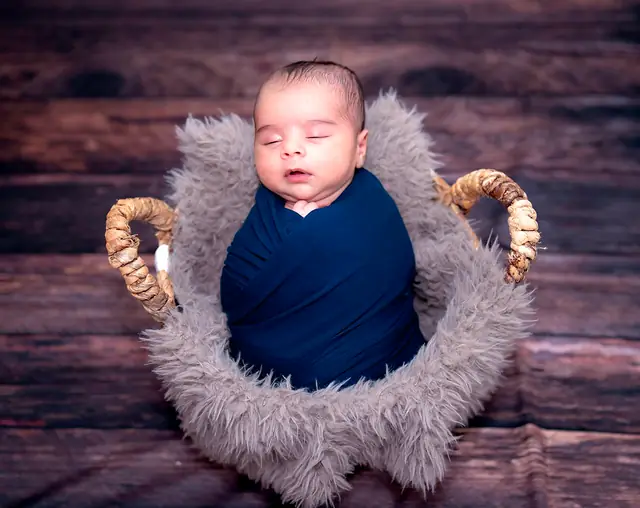 Wrapped newborn in fur bowl prop