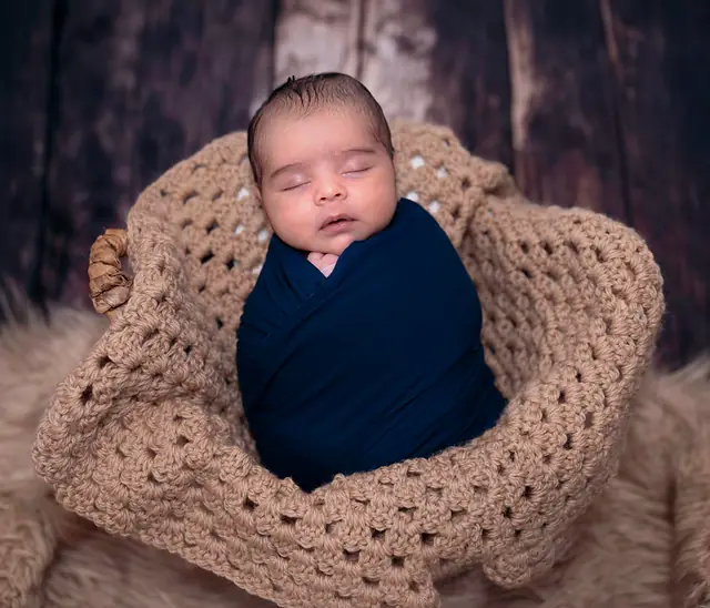 Wrapped newborn in knitted basket