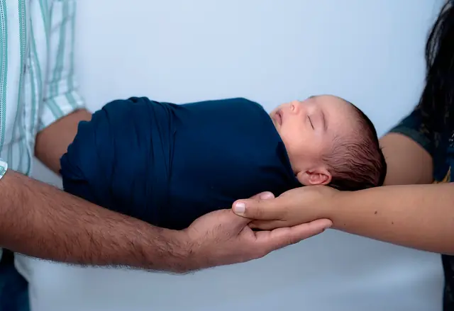 Wrapped newborn in father's hands