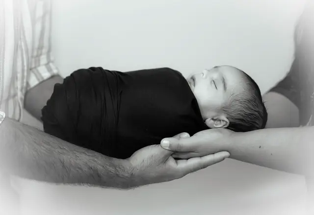Black and white newborn in father's hands