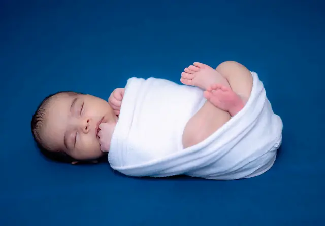 Newborn wrapped in white