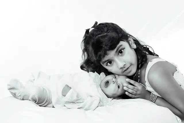 Big sister with newborn, black and white