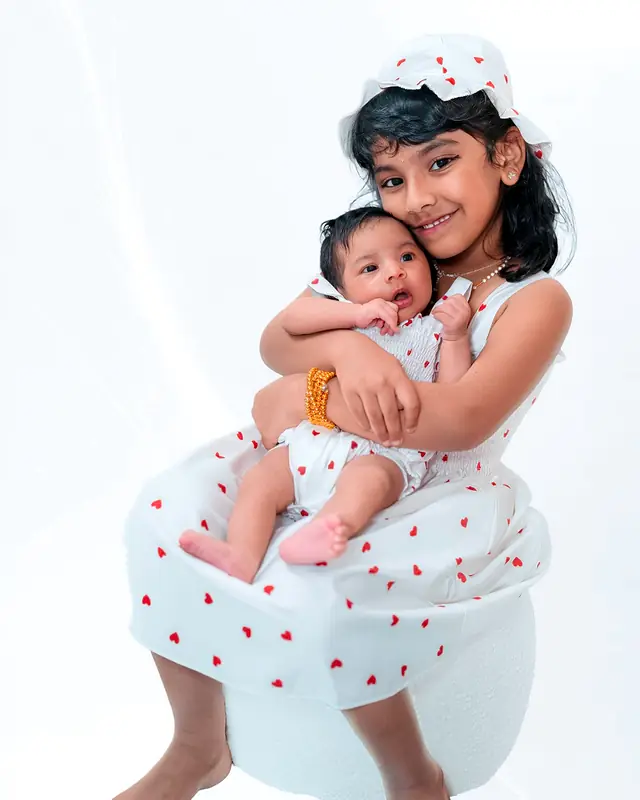 Big sister holding newborn