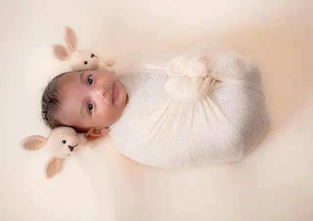 Newborn in cream wrap with teddy