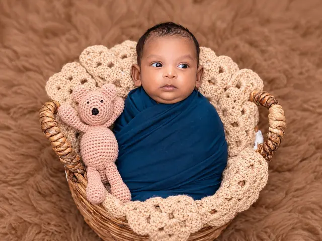 Newborn in basket with teddy