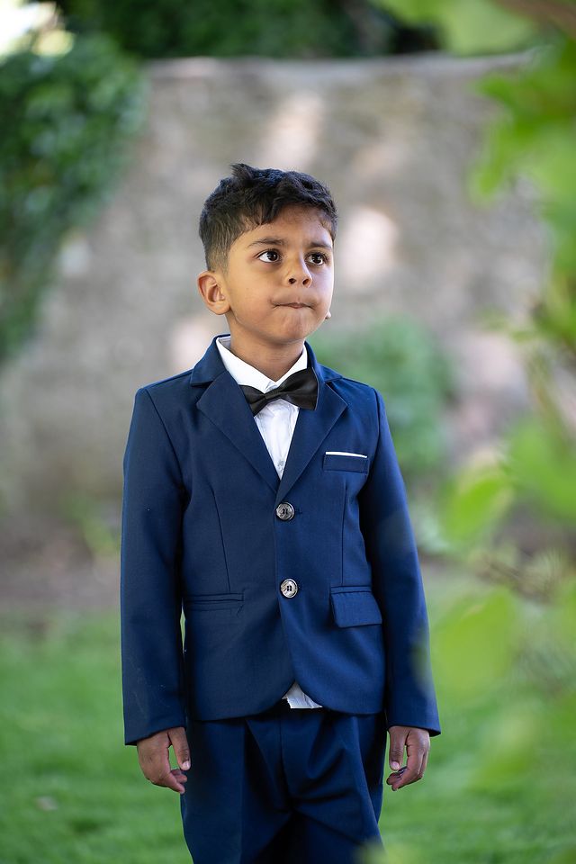 Boy in a navy suit photographed outdoors