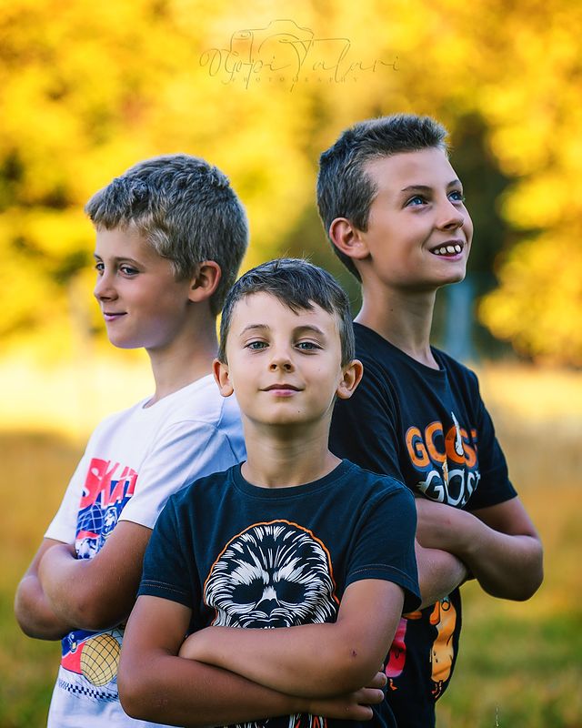 Three brothers smiling together in golden light